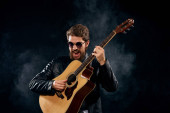 muž v černé kožené bundě drží kytara hudba celebrity životní styl
