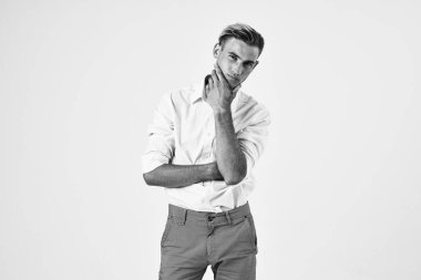 Yakışıklı bir adam beyaz gömlekli yaşam tarzıyla el kol hareketi yapıyor.