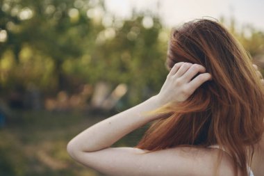 Beyaz elbiseli kadın doğa yürüyüşü yapıyor.