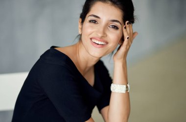 Siyah elbiseli, neşeli, güzel bir kadın. Saç stili.