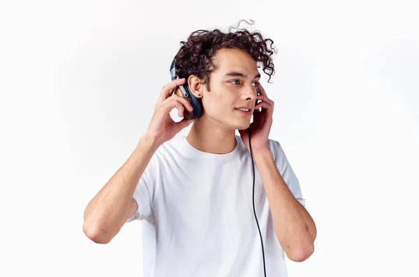 Σγουρά μαλλιά τύπος σε λευκό t-shirt με ακουστικά μουσική ψυχαγωγία τεχνολογία — Φωτογραφία Αρχείου
