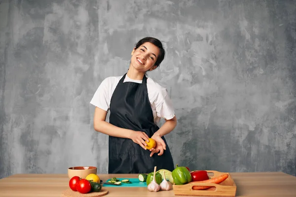 Femme au foyer sur la cuisine couper les légumes fond isolé — Photo