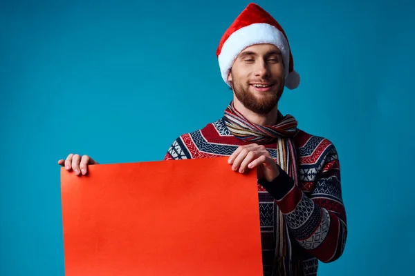 Bel homme dans un chapeau de Père Noël tenant une bannière vacances fond isolé — Photo