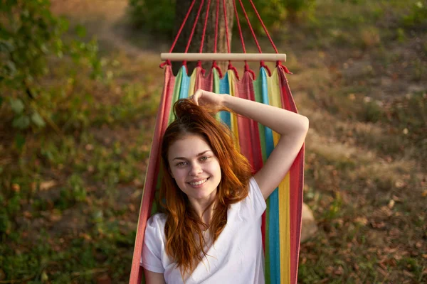 Glad kvinna i naturen ligger i en hängmatta vila komfort — Stockfoto