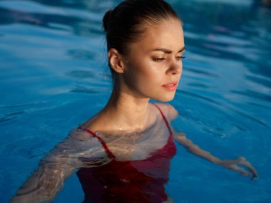 Havuzda mayolu bir kadın var. Gözleri kapalı.