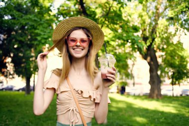 Güzel bir kadın, açık hava bardağıyla yaz tatilinde içki içiyor.