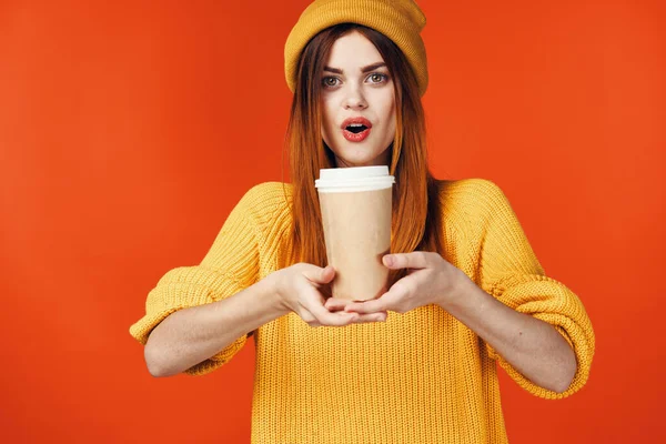 Jolie femme en chapeau jaune avec une tasse de boisson chaude dans les mains émotions fond isolé — Photo