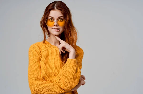 Hermosa mujer en un suéter amarillo gafas de moda aislado fondo — Foto de Stock
