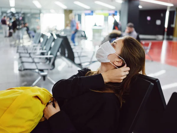 Pasajeros máscara médica aeropuerto esperando vuelo mochila amarilla — Foto de Stock