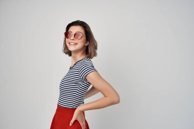 Güneş gözlüklü, kırmızı etekli neşeli kadın.