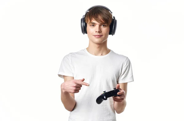 Chico en camiseta blanca con auriculares jugando videojuegos gamer — Foto de Stock