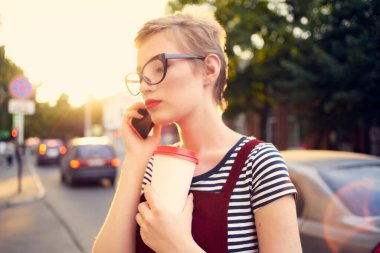 Güneş gözlüğü takan güzel bir kadın yakın plan çekimde poz veriyor.
