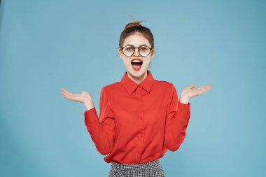 Kırmızı tişörtlü neşeli kadın. Duygularını mesleki mavi arka planda yaşıyor.