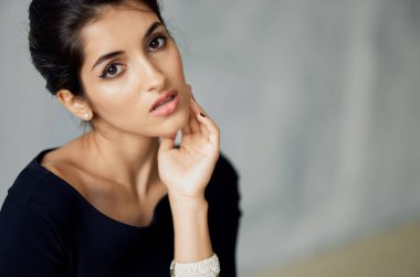 Siyah elbiseli çekici kadın cazibeli poz veriyor.