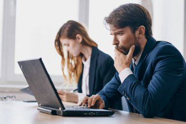 Bir dizüstü bilgisayarın önünde oturan iş arkadaşları internet profesyonelleri