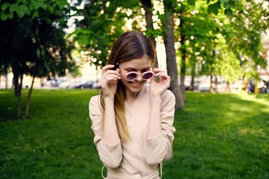 Bu yaz şehir gezisinde güzel bir kadın parkta yürüyor.