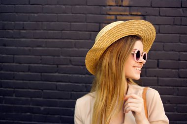 Duvarın yanında şık elbiseli bir kadın sokakta yürüyor.