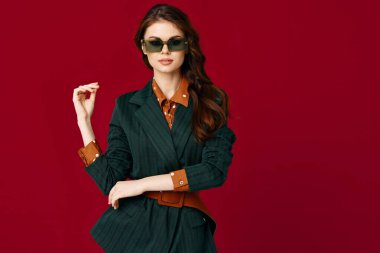 Moda kıyafetli esmer modern tarz güneş gözlüğü takılı arka plan