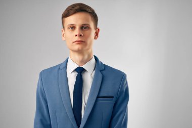 Takım elbiseli bir iş adamı bir defter yöneticisine yazı yazar.