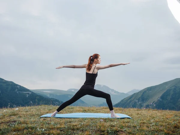 Kadın dağlarda meditasyon yapıyor yoga yapıyor, temiz hava alıyor. — Stok fotoğraf