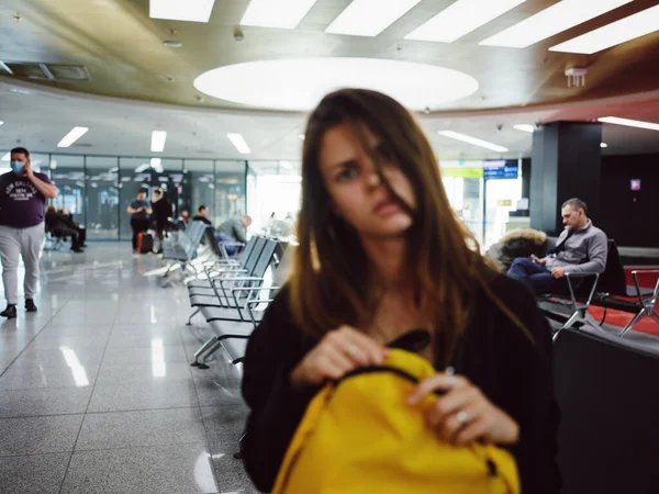 Пассажир аэропорта желтый рюкзак ожидания недовольство — стоковое фото