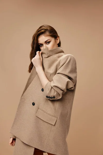 Mulher fecha com casaco bege e olha para a frente vista lateral — Fotografia de Stock