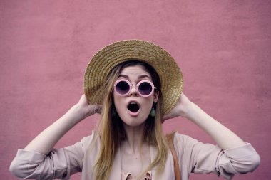 Güzel bir kadın, dışarıda yürüyor. Moda, yaz, pembe duvar gezisi.