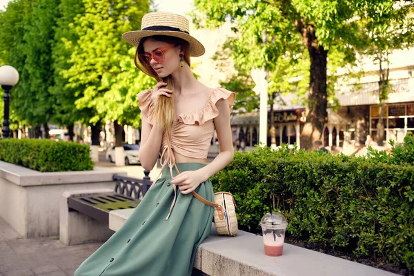 Ładna kobieta w kapeluszu w parku pić reszta zieleni — Zdjęcie stockowe