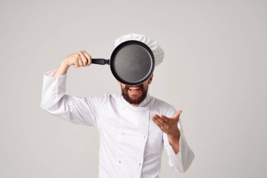Elinde kızartma tavası olan sakallı aşçı adam.