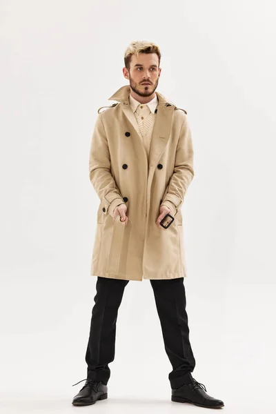 Hombre en abrigo de moda de longitud completa posando fondo aislado estilo moderno — Foto de Stock