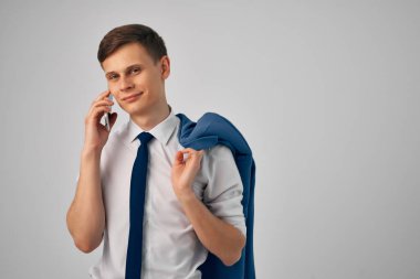 İş adamı omzunda bir ceketle telefon iletişimi internet teknolojisiyle çalışıyor.