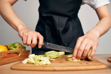 Ev hanımı mutfakta sebze doğruyor sağlıklı vitamin yiyor.