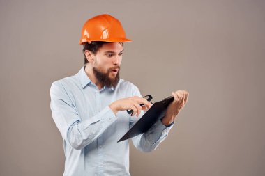 Sakallı adam elinde belgelerle koruyucu üniforma çiziyor.