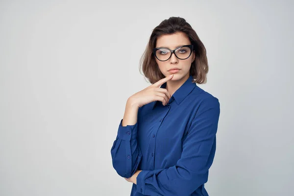 Donna d'affari in camicia blu indossando occhiali glamour posa sfondo chiaro — Foto Stock