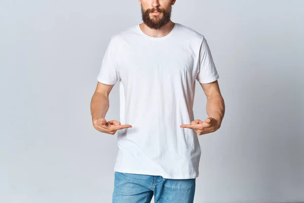 Mężczyzna w białej koszulce i dżinsy makieta reklama światło tło — Zdjęcie stockowe
