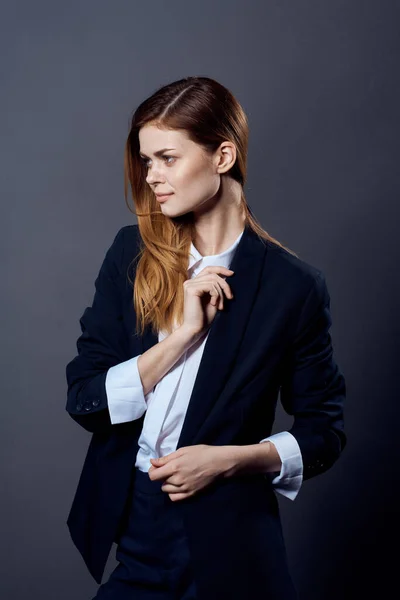 woman in business suit fun posing dark background