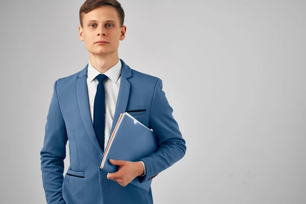 Homme dans un costume avec un dossier bleu dans ses mains bureau officiel — Photo