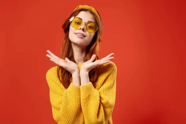 Kvinna i gul tröja hippie tillbehör retro stil röd bakgrund — Stockfoto