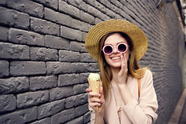 Güzel bir kadın dışarıda yürüyor dondurma yiyor, seyahat ediyor, eğleniyor.