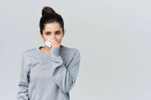 Vrouw in grijs trui veegt haar gezicht met een zakdoek gezondheidsproblemen — Stockfoto