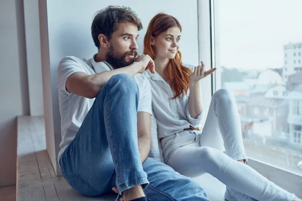Hombre y mujer se sientan cerca de la ventana con auriculares juntos apartamentos — Foto de Stock