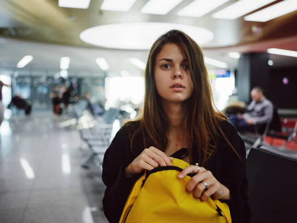 Femme assise à l'aéroport sac à dos jaune en attente d'un vol — Photo