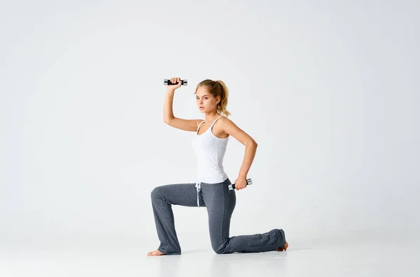 Mujer deportiva de rodillas ejercicio de motivación ejercicio con pesas —  Fotos de Stock