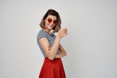 Çizgili tişörtlü kadın güneş gözlüğü takıyor.