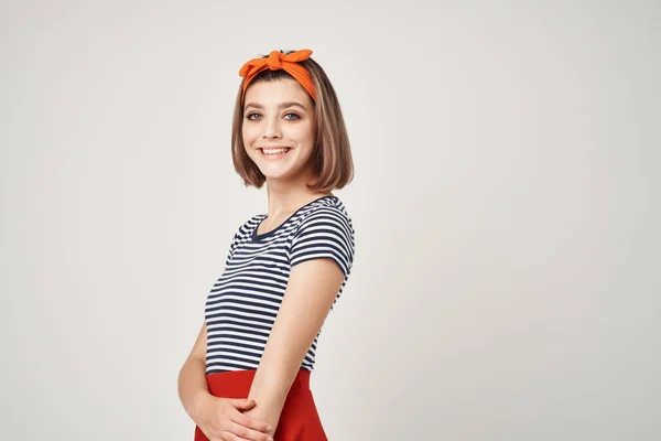 Vrouw in gestreept t-shirt studio poseren oranje verband — Stockfoto