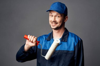 İş üniformalı bir adam bir apartman dekorasyonunu boyayan bir adam.