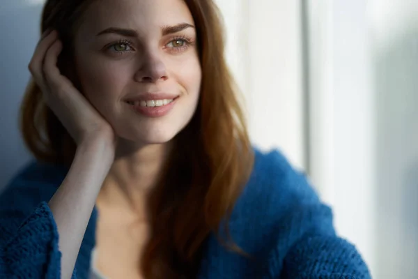 Vrouw zittend op de vensterbank met een blauwe ruitensteun Lifestyle — Stockfoto