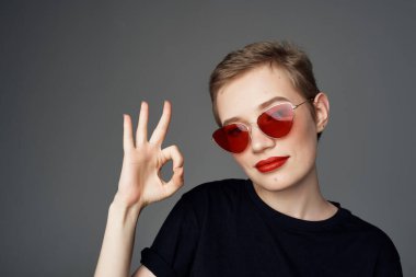 Kısa saçlı, güneş gözlüklü, izole bir geçmişi olan bir kadın.