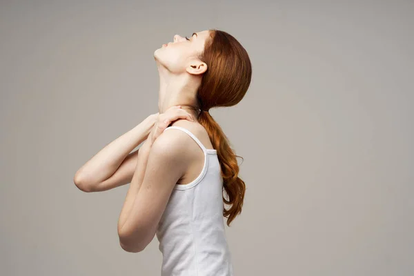 Γυναίκα σε λευκό t-shirt ρευματισμούς πόνος στο λαιμό προβλήματα υγείας φως φόντο — Φωτογραφία Αρχείου