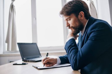 Yönetici bir dizüstü bilgisayarın önünde oturuyor. Finans uzmanı.